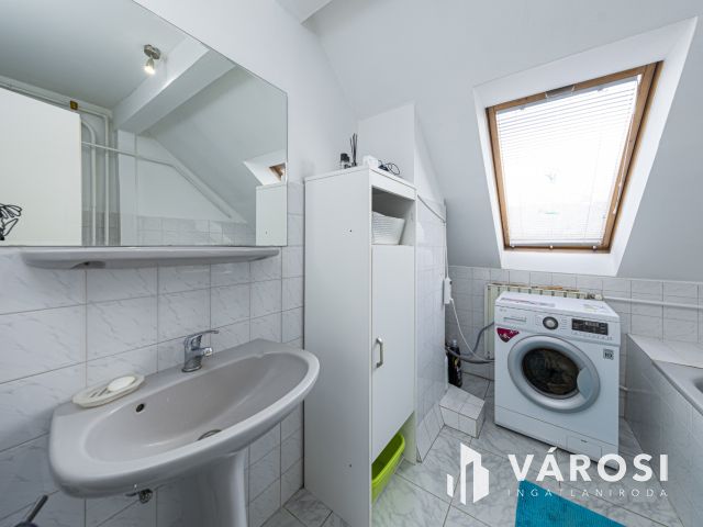 Látszó fagerendás tetőtéri lakás csendes utcában